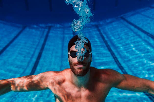 IMAGO Creative: Sport Dichotomien - Land und Wasser Professional young male swimmer swimming underwater model released Symbolfoto EBBF01313