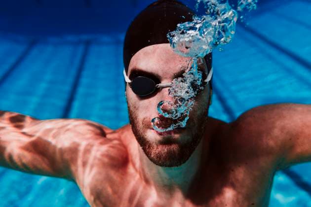 IMAGO Creative: Kulturelle Folgen der Pandemie: Gesundheitsbewußtsein und Alleinsein Young male swimmer diving in swimming pool model released Symbolfoto EBBF01314