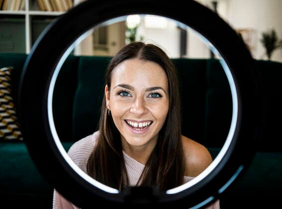 IMAGO Creative: Digitale Welt, Social Commerce Happy female influencer with illuminated lighting equipment at home model released Symbolfoto property released GIOF09463