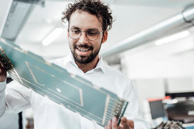 IMAGO Creative: Corporate: Klimaschutz, Digitalisierung und Urbanisierung IMAGO Creative: Klimawandel - Grüne Erholung Smiling male engineer examining large computer chip in industry model released Symbolfoto property released JOSEF02161