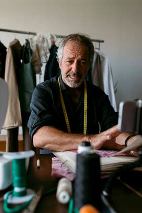 Male costume designer vlogging through smart phone at work studio model released Symbolfoto property released VABF03728