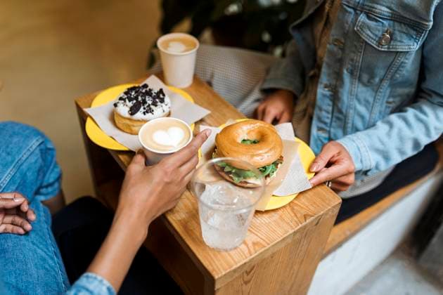 Friends having food and coffee while sitting at cafe model released Symbolfoto VABF03915