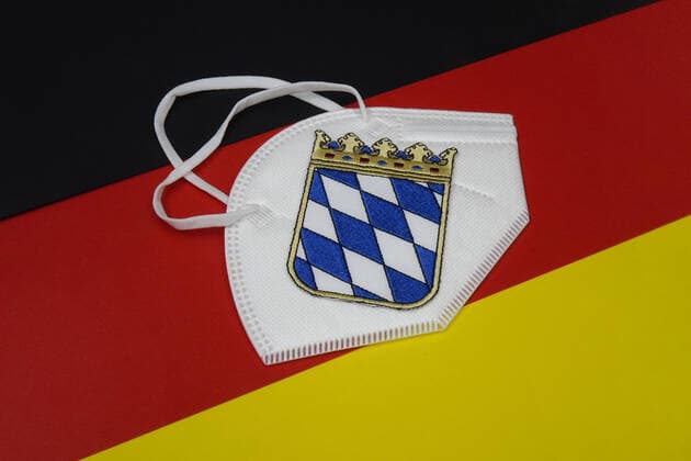 Deutschlandfahne mit FFP2-Maske und Wappen Deutschlandfahne mit FFP2-Maske und Wappen, 14.01.2021, Borkwalde, Brandenburg, Auf einer Deutschlandfahne liegt eine FFP 2 Maske mit dem Wappen von Bayern.