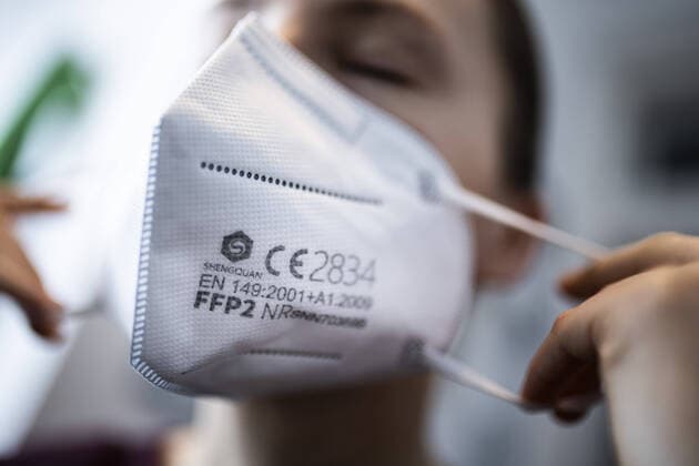 Eine Frau setzt eine FFP2-Maske auf, aufgenommen in Berlin, 15.01.2021. Aufgrund des sich noch immer ausbreitenden Corona-Viruses gibt es eine Diskussion ueber eine generelle Pflicht zum Tragen eines FFP2-Mundschutzes. Berlin Deutschland