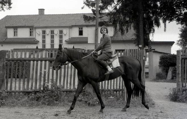 09.07.1964, Gotha, Bezirk Erfurt, DDR - Frau macht einen Ausritt. Galopprennbahn Gotha-Boxberg. (Pferd, Frau, Ausritt, Ausreiten, Morgenarbeit, Training, Strasse, Haus, Wohnhaus, Gebaeude, Gefahr, gefaehrlich, kein Helm, keine Kappe, kein Kopfschutz, helmlos, kappenlos, historisch, schwarz-weiss) 640709A069GOTHA.JPG *** 09 07 1964, Gotha, district Erfurt, DDR woman makes a ride gallop racecourse Gotha Boxberg horse, woman, ride, riding out, morning work, training, street, house, dwelling house, building, danger, dangerous, no helmet, no cap, no head protection, helmetless, capless, historical, black white 640709A069GOTHA JPG