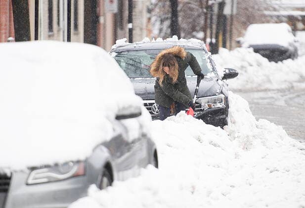 January 17, 2021, Montreal, PQ, Canada: A woman clears snow from around her car following the first snowstorm of the year in Montreal, Sunday January 17, 2021. Montreal Canada  - ZUMAc35_ 20210117_zaf_c35_004 Copyright: xGrahamxHughesx