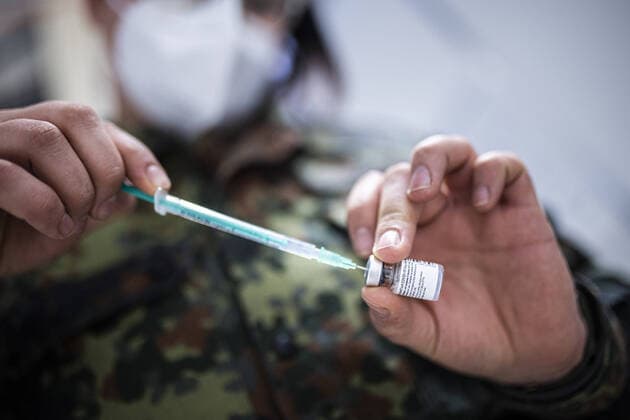 Eine Spritze wird durch eine Soldatin aufgezogen mit dem Corona-Impfstoff von Biontech und Pfizer, aufgenommen im Impfzentrum in Schoenefeld, 19.01.2021. Schoenefeld Deutschland *** A syringe is drawn up by a soldier with the Corona vaccine from Biontech and Pfizer, taken at the vaccination center in Schoenefeld, 19 01 2021 Schoenefeld Germany Copyright: xFlorianxGaertner photothek.dex
