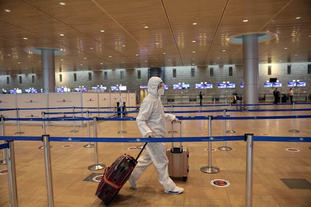 (210120) -- TEL AVIV, Jan. 20, 2021 -- A passenger wearing a protective suit and mask walks at Ben Gurion International Airport near Tel Aviv, Israel, Jan. 19, 2021. Israel s cabinet decided on Tuesday to extend by 10 days a weeks-long nationwide lockdown to curb the spread of the COVID-19 pandemic. The ministers voted in favor of extending the tight lockdown until Jan. 31, according to a cabinet statement. The cabinet also decided that travelers entering the country will be required to present a negative coronavirus test taken within 72 hours before their flight. (Gideon Markowicz JINI via Xinhua) ISRAEL-TEL AVIV-AIRPORT-COVID-19 ShangxHao 