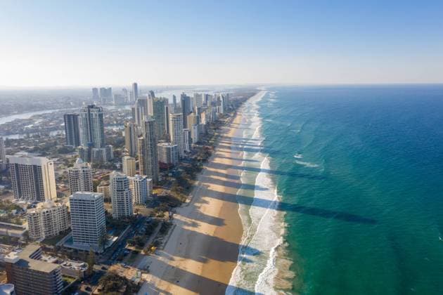 Breathtaking aerial view of modern skyscrapers located near famous sandy Surfers Paradise Beach washing by powerful ocean in Queensland, Model released Copyright: xJordixBatallerx MR