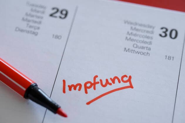 Symbolfoto Eintragung der Corona Impfung in den Terminkalender Symbolbild, Eintrag und Notiz des Impfetermin fuer eine Corona Impfung mit einem roten Stift in den aktuellen Tageskalender 2021 Deutschland