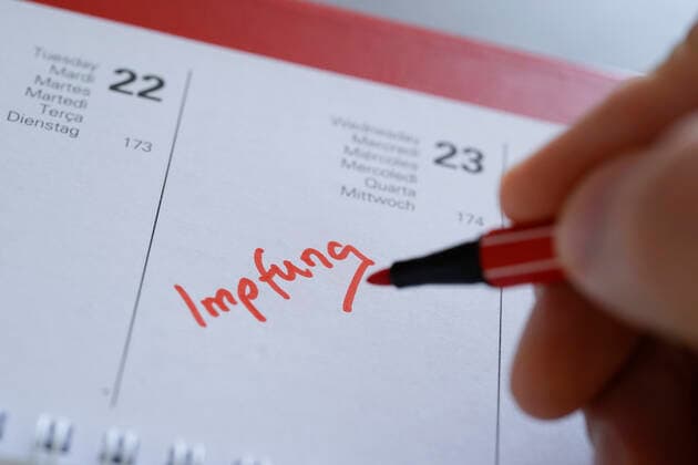 Symbolfoto Eintragung der Corona Impfung in den Terminkalender Symbolbild, Eintrag und Notiz des Impfetermin fuer eine Corona Impfung mit einem roten Stift in den aktuellen Tageskalender 2021 Deutschland