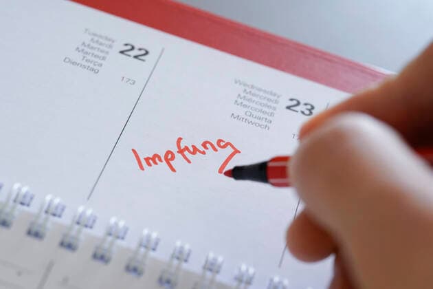 Symbolfoto Eintragung der Corona Impfung in den Terminkalender Symbolbild, Eintrag und Notiz des Impfetermin fuer eine Corona Impfung mit einem roten Stift in den aktuellen Tageskalender 2021 Deutschland