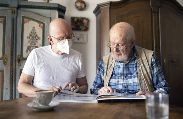 Thema: Altenpflege. Altenpfleger bei der Arbeit mit Patient in haeuslichen Umfeld schauen in ein Fotobuch. Heidelberg Deutschland *** theme geriatric care geriatric nurse at work with patient in home environment look into a photo book Heidelberg Germany Copyright: xUtexGrabowsky photothek.netx