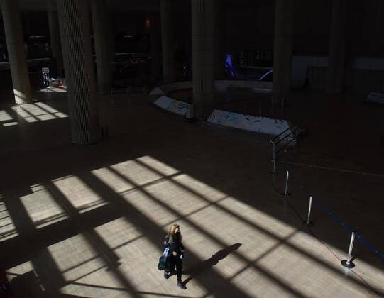 A woman walks in an empty arrival hall in Israel s Ben Gurion Airport in Lod, near Tel Aviv, on Sunday, January 24, 2021.  JER2021012416 DEBBIExHILL