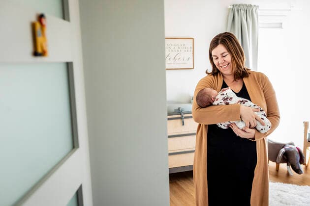 Smiling mother carrying newborn baby while standing in nursery model released Symbolfoto property released AWAF00013