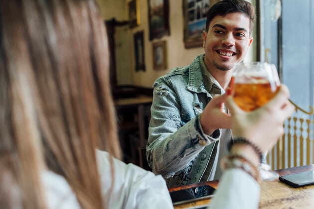 IMAGO Creative: Landleben - Essen Happy friends smiling while toasting drinks in bar model released Symbolfoto property released EGAF01286
