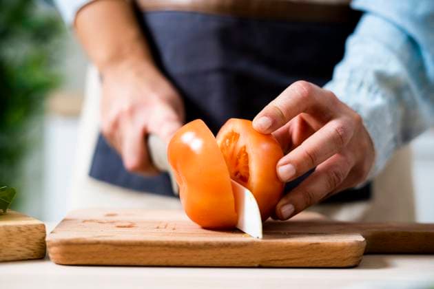 Hands of woman slicing tomato on cutting board model released Symbolfoto property released GIOF10356