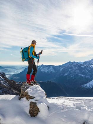IMAGO Creative: Alternativer Wintersport Male hiker using smart phone while standing on snowy mountain against sky, Orobic alps, Lecco, Italy model released Symbolfoto MCVF00695