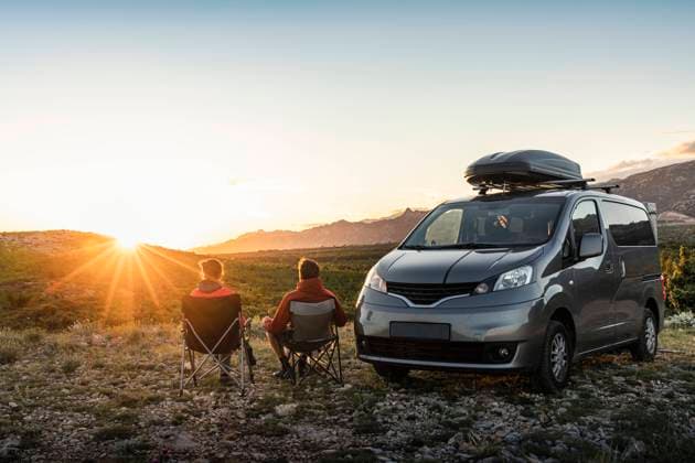 IMAGO Creative: Herbst, Touren mit dem Camper Man and woman sitting near camper van, looking at landscape at sunset model released Symbolfoto property released MSUF00358