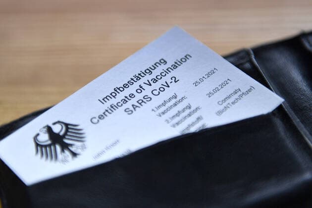 Themenbild Symbolfoto: Digitaler Impfpass,Impfbestaetigung,Plastikkarte,Scheckkarte steckt in einem Portemonnaie.