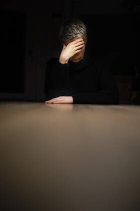 Symbolfoto zum Thema Einsamkeit und Isolation: Eine Frau sitzt nachts allein am Tisch und haelt sich die Haende vor das Gesicht, 23.01.2021. Berlin Deutschland *** Symbolic photo on the subject of loneliness and isolation A woman sits alone at the table at night and holds her hands in front of her face, 23 01 2021 Berlin Germany Copyright: xThomasxTrutschel xphotothek.dex