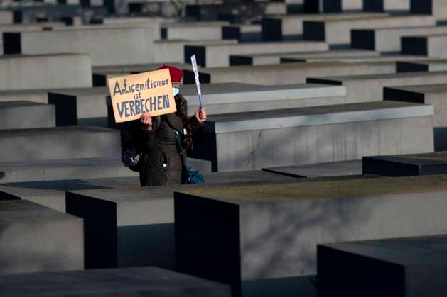 Holocaust Memorial - Anniversary Of The Liberation Of Auschwitz Deu, Deutschland, Germany, Berlin, 27.01.2021 Frau der Initiative Omas Gegen Rechts mit Schild Antisemitismus ist Verbrechen neben einer Stele vom Holocaust Mahnmal bei der Gedenkveranstaltung fuer die ermordeten Juden Europas am Holocaust-Mahnmal und der Gedenkstaette Topographie des Terrors in Berlin. In Gedenken am 76. Jahrestag der Befreiung von Auschwitz veranstaltet die juedische Gemeinde und antifaschistische Initiativen unter dem Motto Kein Vergessen Kein Vergeben zur Erinnerung an die ermordeten Juden Europas im Dritten Reich. Women of the initiative Omas Gegen Rechts, Grandmas against Rights Wing, with sign Antisemitismus ist Verbrechen Anti-Semitsm is A Crime next to