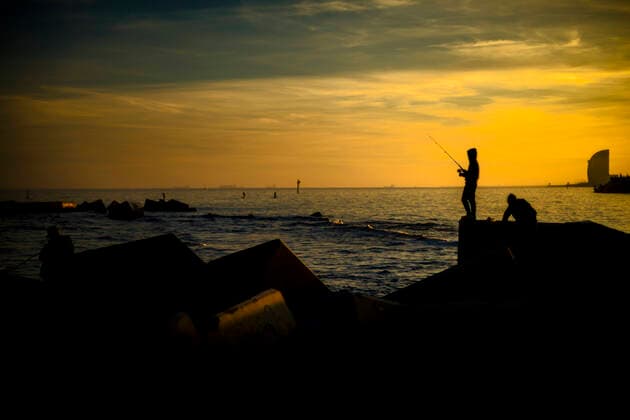 January 28, 2021, Barcelona, Catalonia, Spain: Commuters fish at a breakwater at Barcelona s seafront during sunset Barcelona Spain - ZUMAo105 20210128_zap_o105_003 Copyright: xMatthiasxOesterlex