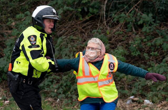 January 29, 2021, Vancouver, BC, Canada: A member of the Vancouver Police Department stops a member of the Extinction Rebellion from crossing the blocked highway as the group blocked the entrance to the Port of Vancouver, Friday, January 29, 2021. The protesters planned the march and blockade as a part of their anti-pipeline campaign. Vancouver Canada  - ZUMAc35_ 20210129_zaf_c35_072 Copyright: xJonathanxHaywardx