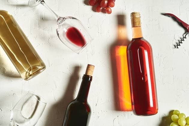 Top view arrangement of fine red and white wines lying on cracked surface amidst wineglasses and grapes Copyright: xMarisolxOgandox Model Released