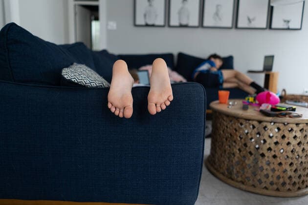 IMAGO Creative: Jahreszeit Winter, Fantasievoll drinnen spielen feet and toes of child laying on couch with brother in background La Grange Park, IL, United States CR_JERE210106-586958-01 ,model released, Symbolfoto ,property released