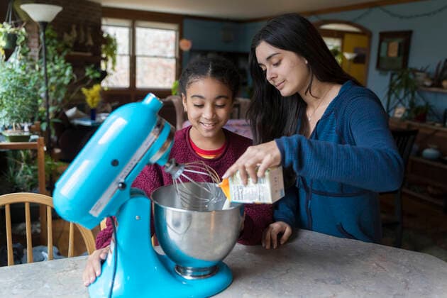 A biracial teen and tween girl make whipped cream together Brewster, MA, United States CR_JUCU210129B-590324-01 ,model released, Symbolfoto
