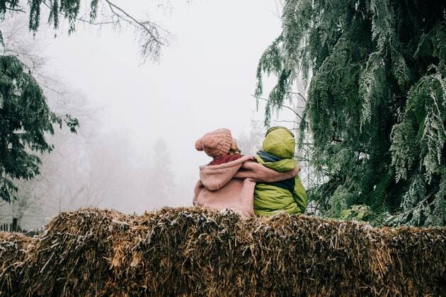 Creative Highlights Symbolbilder two friends hugging sat outside together enjoying the winter scene Winchester, England, United Kingdom CR_RABE210119-614784-01 ,model released, Symbolfoto