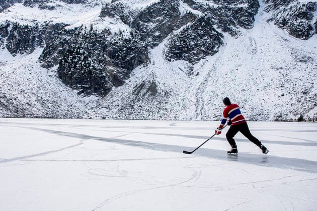 IMAGO Creative, Winter, Winterspaß, Eishockey #2 Unrecognizable hockey player ice skating on frozen lake near mountain Canada, British Columbia, Pemberton CR_PSFZ210201-623647-01 ,model released, Symbolfoto
