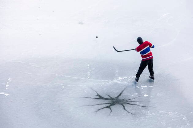IMAGO Creative, Winter, Winterspaß, Eishockey #2 Creative Highlights Symbolbilder From above unrecognizable hockey player shooting puck on ice in Canada Canada, British Columbia, Pemberton CR_PSFZ210201-623658-01 ,model released, Symbolfoto