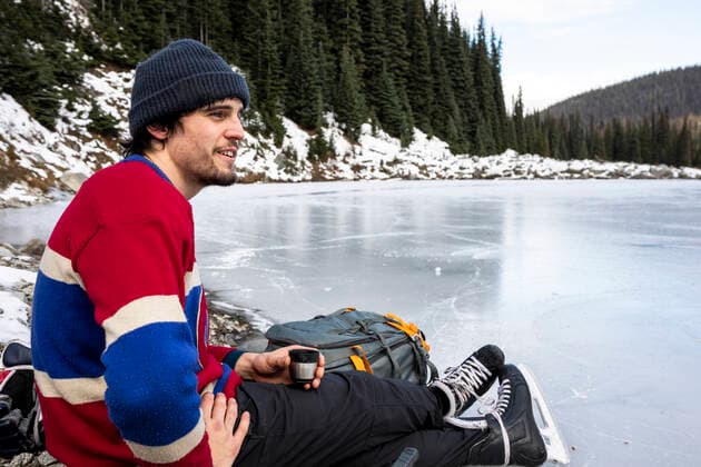 IMAGO Creative, Winter, Winterspaß, Eishockey #2 IMAGO Creative, Jahreszeit Winter, Eislaufen Young hockey player resting near frozen lake and drinking hot beverage Canada, British Columbia, Pemberton CR_PSFZ210201-623663-01 ,model released, Symbolfoto