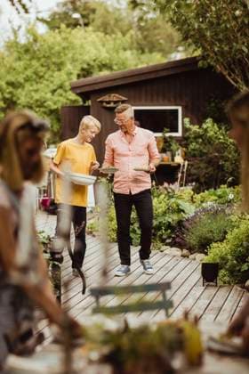 IMAGO Creative: Landleben - Essen Father and son walking with bowl and plate in back yard during social event Sweden, Gothenburg, model released, property released Copyright: xMaskotx , MA83799