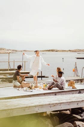 IMAGO Creative: Landleben - Alfresco, Draußen Young friends enjoying on jetty at harbor during picnic Sweden, Gothenburg, model released Copyright: xMaskotx , MA83864
