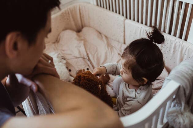 IMAGO Creative: Vaterschaft Father looking at baby son playing in crib at home Sweden, Stockholm, model released, property released Copyright: xMaskotx , MA83948