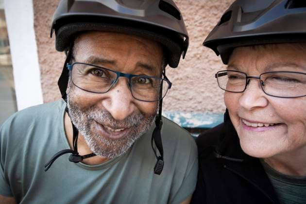 Smiling couple with cycling helmet outside house Sweden, Stockholm, model released, property released Copyright: xMaskotx , MA84006