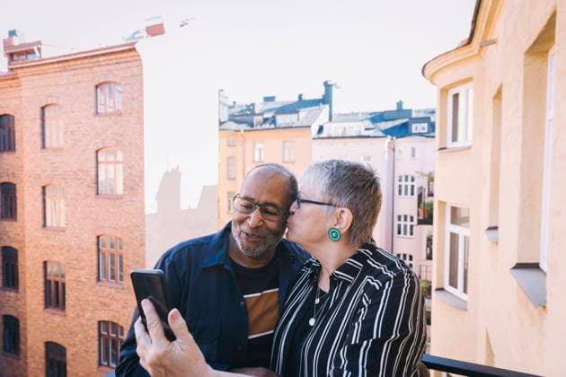 Woman kissing man while taking selfie on smart phone in balcony Sweden, Stockholm, model released, property released Copyright: xMaskotx , MA84032
