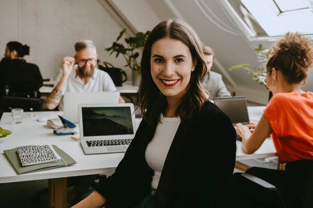 Creative Highlights Symbolbilder Smiling young businesswoman sitting with colleagues in coworking office Germany, Berlin, model released, property released Copyright: xMaskotx , MA84159
