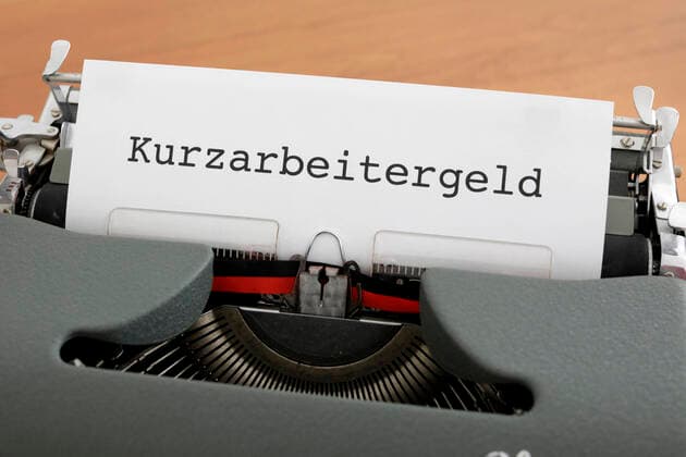 In einer Schreibmaschine ist ein Blatt Papier mit dem Schriftzug Kurzarbeitergeld eingespannt, DEU, Berlin, 05.02.2021 *** A sheet of paper with the writing Kurzarbeitergeld is clamped in a typewriter, DEU, Berlin, 05 02 2021