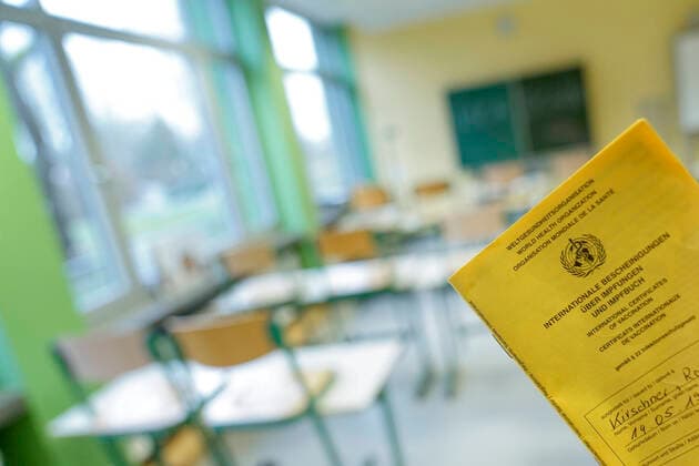 Symbolbild Schule und Klassenzimmer im Lockdown Symbolfoto eines Impfpass mit Klassenzimmer einer Schule im Hintergrund. Lehrer sind aktuell in der Risikogruppe drei und spaeter bei der Impfung Deutschland
