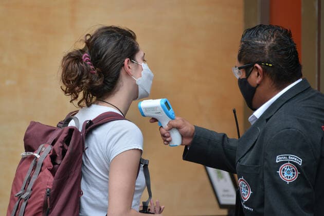 February 9, 2021, Mexico City, Mexico City, USA: A workers checks temperature to a person before she enters a store to shopping, during the reopening stores after several days. Mayor Victor Hugo Romo Guerra, gave permission to resumption of some stores, that comply with the new measures as scanning a QR code, use face masks and antibacterial solution, check temperature are some of the measures so that people can enter mall centers on February 9, 2021 in Mexico City, Mexico Mexico City USA - ZUMAe321 20210209_zia_e321_004 Copyright: xCarlosxTischlerx