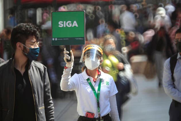 February 9, 2021, Mexico City, Mexico City, Mexico: A officer holds a sign to people follow the rules to prevent agglomerations. The Mexican Government allowed the reopening of stores, some shops make outside sell to prevent crowd of people, as an attempt to prevent spread of the Virus February 9, 2021 in Mexico City, Mexico Mexico City Mexico - ZUMAe321 20210209_zia_e321_028 Copyright: xAngelxMoralesxRizox