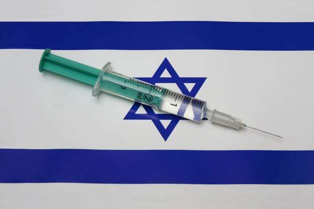 Spritze auf einer Länderflagge Spritze auf einer Länderflagge, 10.02.2021, Borkwalde, Brandenburg, Eine Spritze mit einem Impfstoff liegt auf der Länderflagge von Israel.