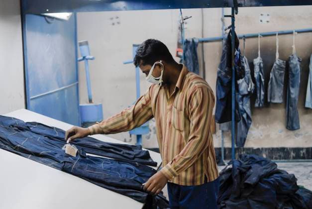 Bangladesh, Textile industry BANGLADESH , textile industry in Dhaka , Beximco textile factory produce Jeans for export for western discounter, department for extra styling like raze and sand with abrasive paper *** BANGLADESCH, Dhaka, Beximco Textilfabrik produziert Jeans fuer den Export fuer westliche Modeketten und Textildiscounter, Abteilung fuer extra styling, schleifen mit Sandpapier Dhaka Bangladesh