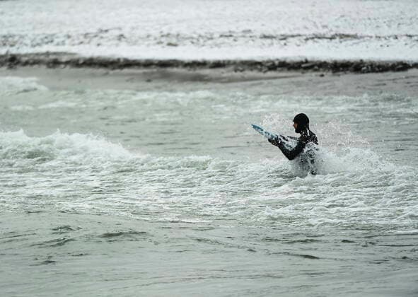 February 12, 2021, Toronto, on, Canada: A man battles the waves as he surfs in the frigid ice cold waters of Lake Ontario during the COVID-19 pandemic in Toronto on Friday, February 12, 2021. Toronto Canada  - ZUMAc35_ 20210212_zaf_c35_027 Copyright: xNathanxDenettex
