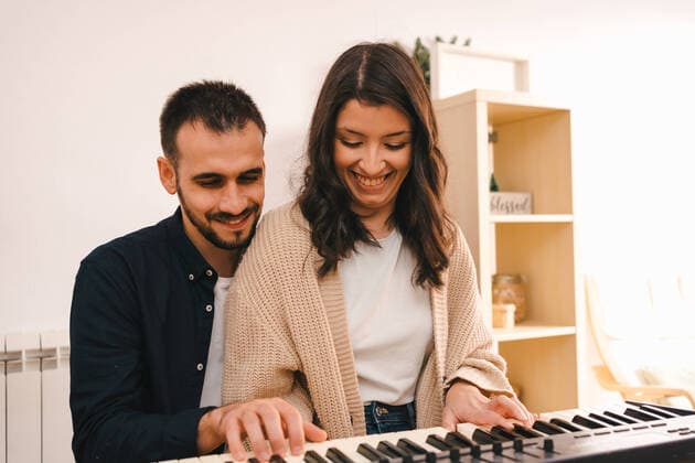 IMAGO Creative: Bildung, Musikerziehung Male musician playing synthesizer and singing together with woman while recording song at home Copyright: xJakexJakabx Model Released
