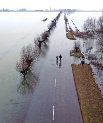 Bilder des Jahres 2021, News 02 Februar News Themen der Woche KW07 People out for a walk along a flooded road as melted snow and floodwater still covers the road from Thorney to Whittlesey, Cambridgeshire. The water levels are dropping but it will quite a few days before the road can be cleaned up and re-opened. 